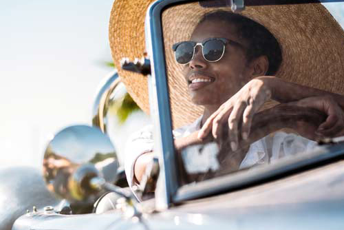 Woman wearing sunglasses and a sunhat driving