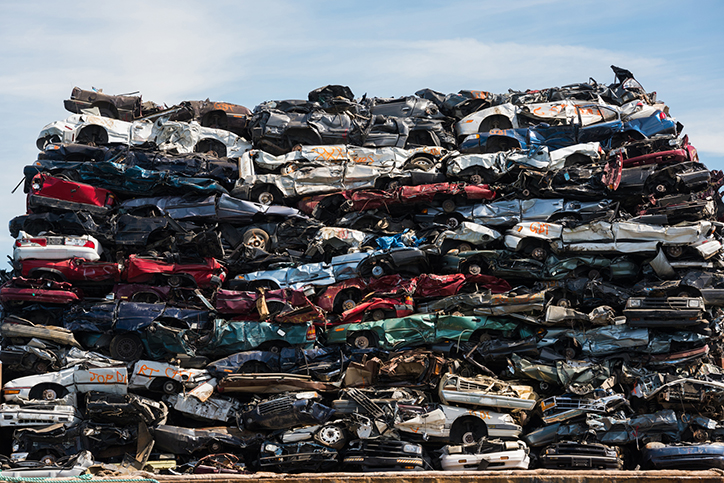 Photo of stacked scrap car shells all different metallic colours