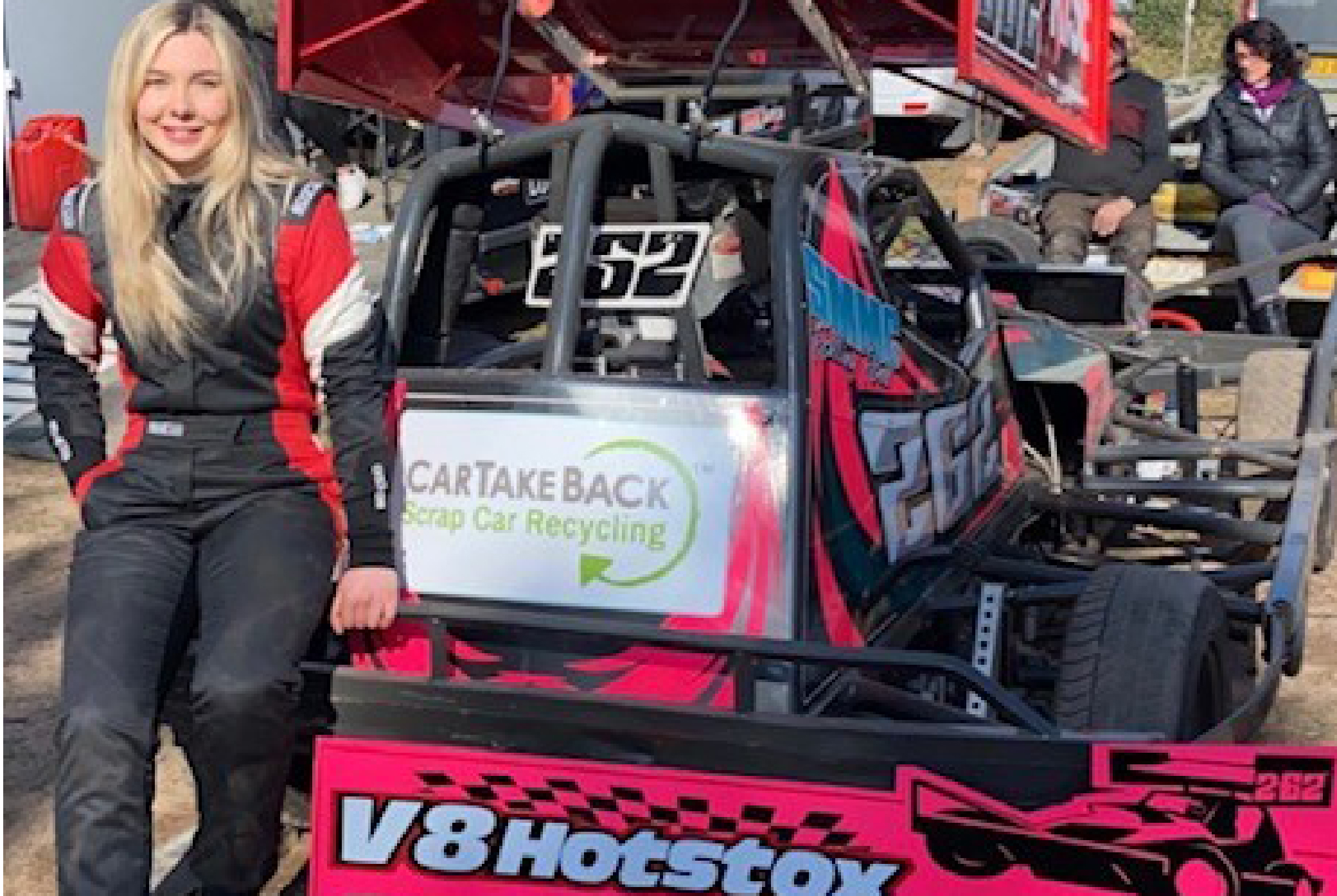 Racing driver Camey Dorrell leaning against her pink and black stock car with the CarTakeBack logo on the rear