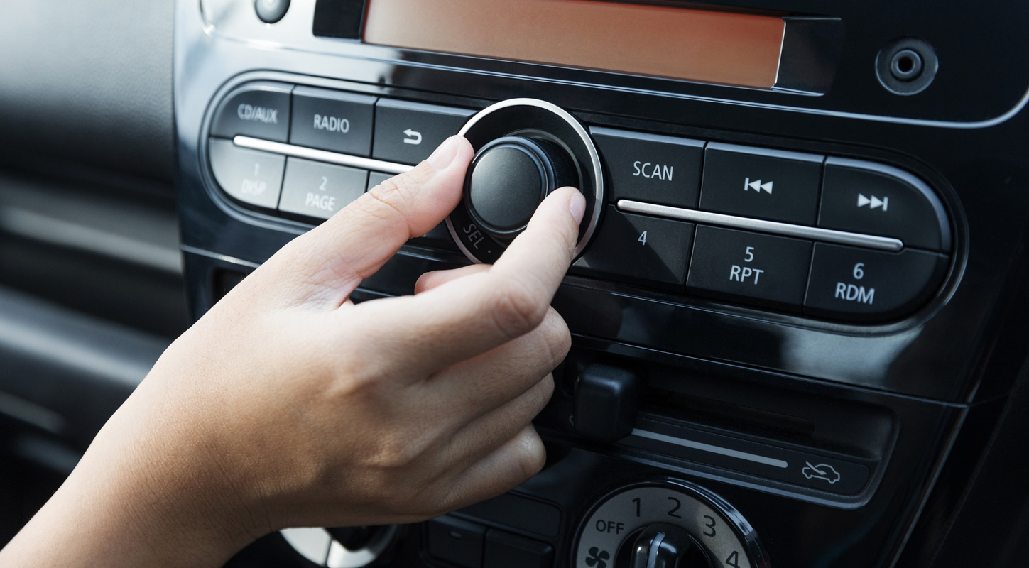 Hand adjusting car stereo volume