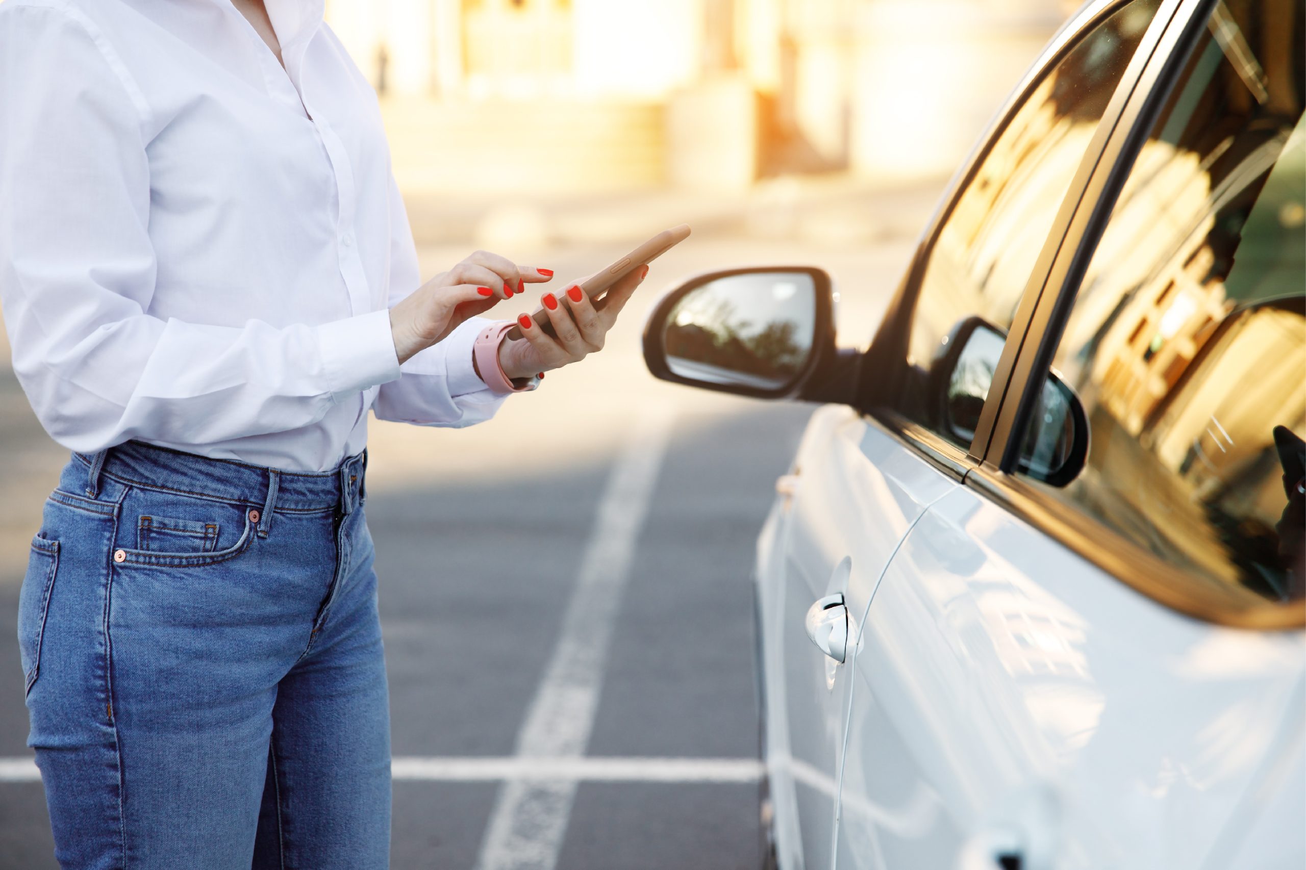 Woman stood next to a car using her phone