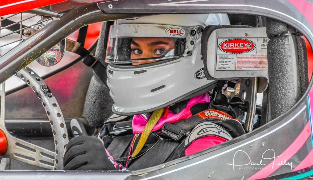 Close up photo of Camey in her vehicle wearing a helmet, just her eyes can be seen