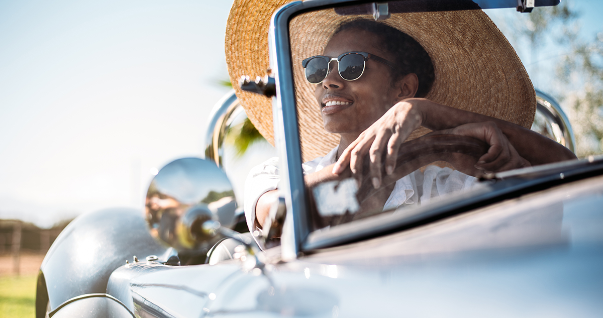 Woman smiling driving in sunshine - being a confident driver