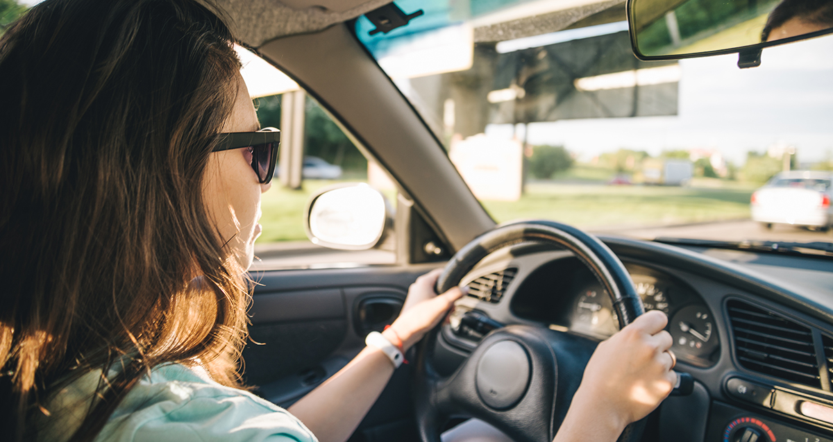 Close up of person with hands on steering wheel - driving skills