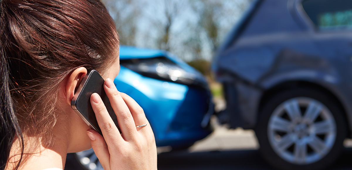 Lady on phone looking at a car crash - reading the road