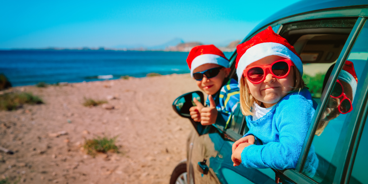 Photo of kids in Santa hats and sunglasses looking out of car windows