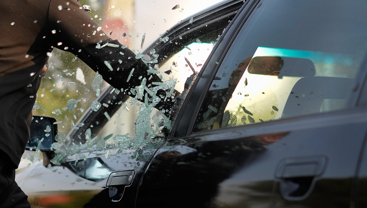 Criminal breaking car window